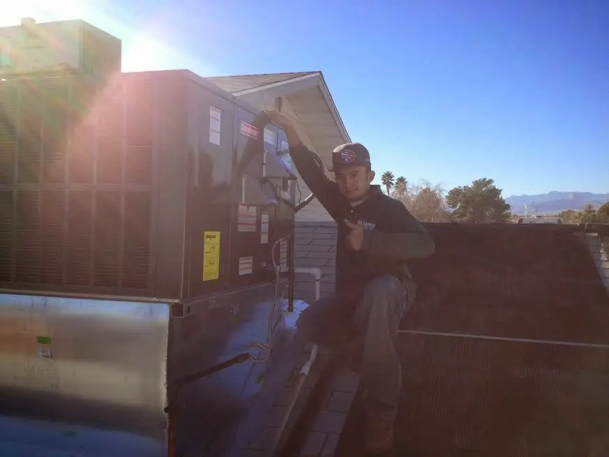 HVAC technician performing AC Tune-Up on a rooftop unit in West Jefferson